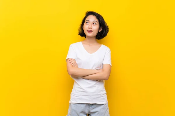 Asiática Joven Mujer Sobre Aislado Amarillo Pared Mirando Hacia Arriba —  Fotos de Stock