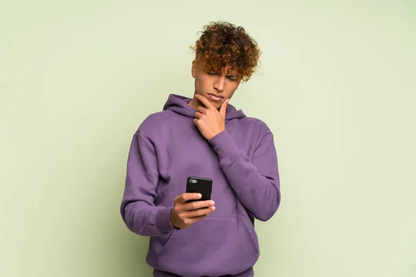 Joven Afroamericano Sobre Aislado Muro Verde Pensando Enviando Mensaje — Foto de Stock