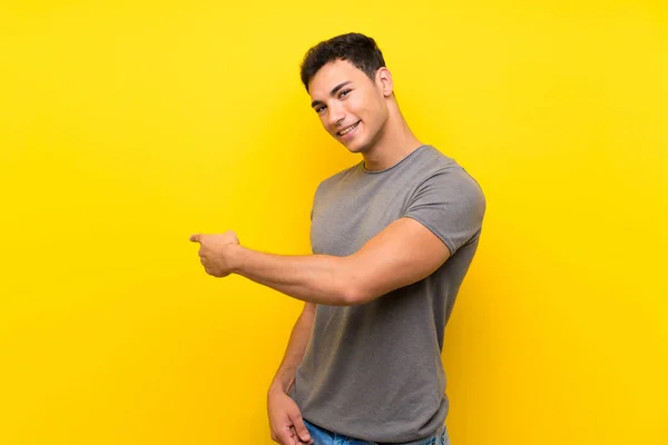 Handsome Man Isolated Yellow Wall Pointing Back — Stock Photo, Image