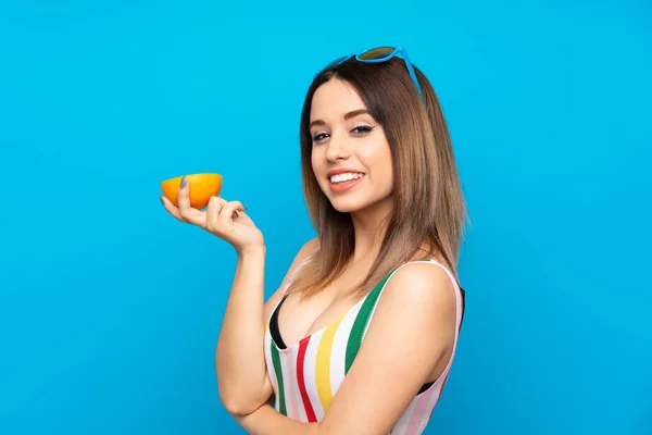 Mujer Joven Vacaciones Verano Sobre Fondo Azul Sosteniendo Una Naranja —  Fotos de Stock