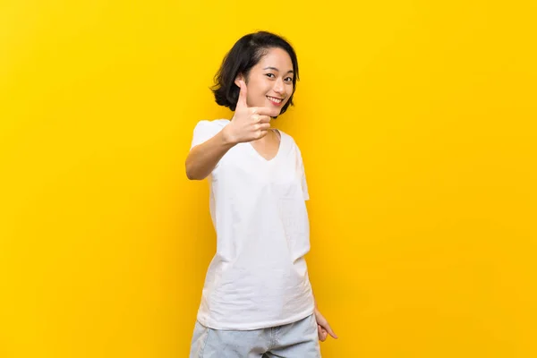 Asiática Joven Mujer Sobre Aislado Amarillo Pared Con Pulgares Hacia —  Fotos de Stock