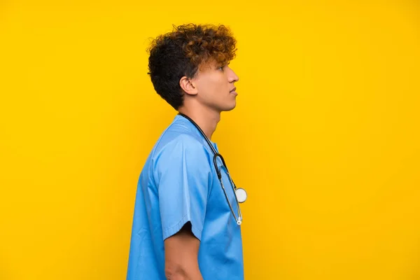 Surgeon doctor african american man keeping arms crossed and looking side