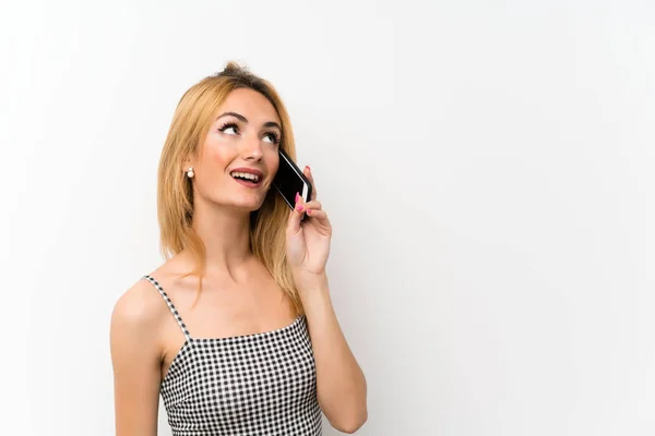 Joven Rubia Sobre Blanco Aislado Manteniendo Una Conversación Con Teléfono — Foto de Stock