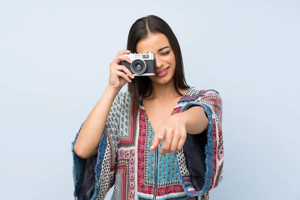 Mujer Joven Sobre Aislada Pared Azul Sosteniendo Una Cámara —  Fotos de Stock