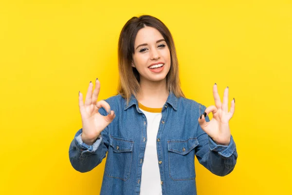 Parmak Ile Işareti Gösteren Sarı Arka Plan Üzerinde Genç Kadın — Stok fotoğraf