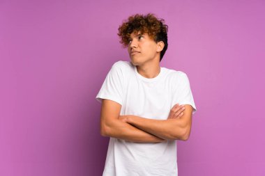 Omuzları kaldırarak izole mor duvar üzerinde genç Afrikalı Amerikalı adam şüphe jest yapma