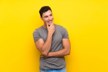 Izole sarı duvar üzerinde yakışıklı adam yan bakıyor