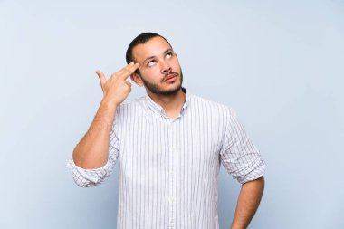 İntihar jest yapma sorunları ile izole mavi duvar üzerinde Kolombiyalı adam