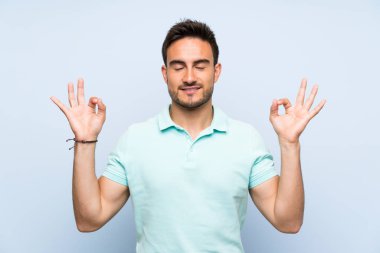 Zen poz üzerinde izole arka plan üzerinde yakışıklı genç adam