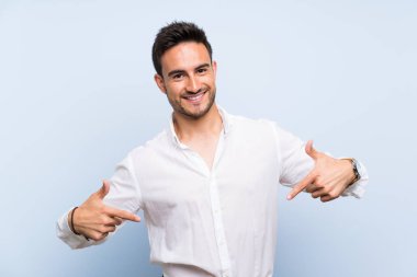 İzole mavi arka plan gururlu ve kendinden memnun üzerinde yakışıklı genç adam