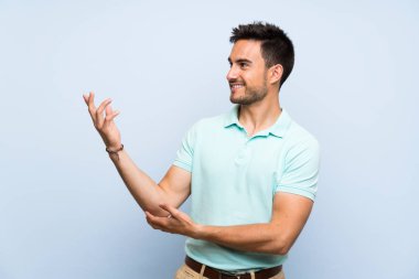 İzole arka planda yakışıklı genç adam gelmek için davet için yan eller uzanan