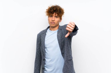 Negatif ifade ile başparmak aşağı gösteren izole beyaz duvar üzerinde moda Afrikalı Amerikan adam