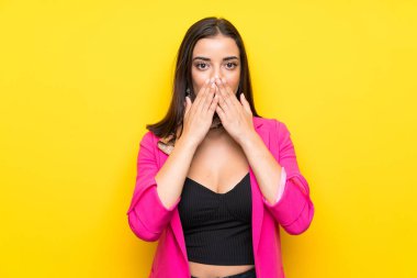 Yüzünde sürpriz ifade olan, izole edilmiş sarı arka planda genç bir kadın.