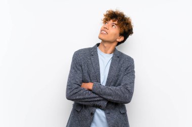 Gülümseyen iken izole beyaz duvar üzerinde moda African Amerikan adam bakıyor