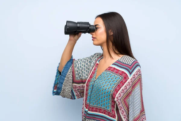 Mujer Joven Sobre Pared Azul Aislada Con Binoculares Negros —  Fotos de Stock