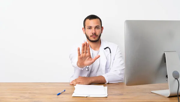 Doctor Colombian man making stop gesture