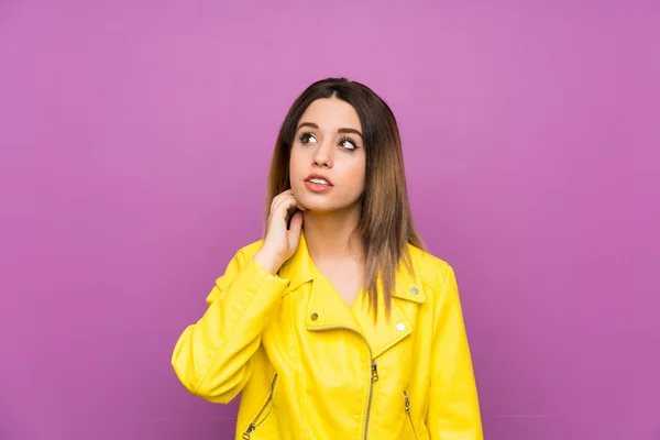アイデアを考える紫色の背景の上の若い女性 — ストック写真