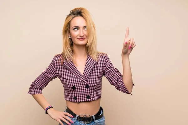 Jonge Blonde Vrouw Met Roze Jas Geïsoleerde Muur Zien Tillen — Stockfoto