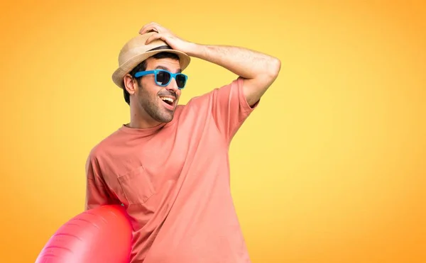 彼の夏休みに帽子とサングラスを持つ男はちょうど何かを実現し オレンジ色の背景に解決策を意図している — ストック写真
