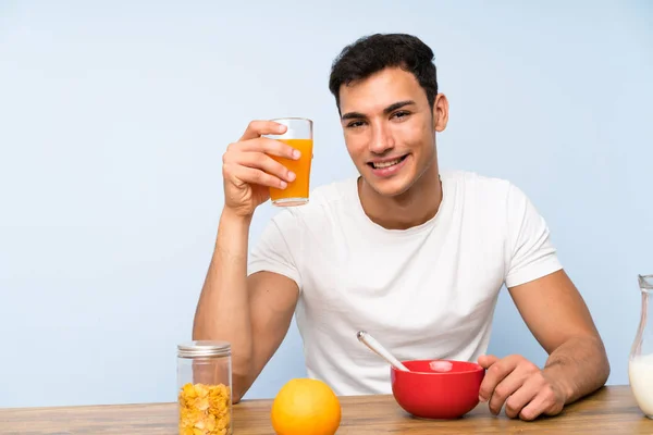 Handsome man holding an orange juice