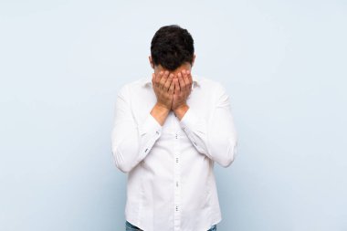 Yorgun ve hasta ifade ile mavi duvar üzerinde Yakışıklı adam