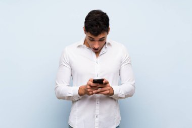 Mavi duvar üzerinde Yakışıklı adam şaşırttı ve bir mesaj gönderme