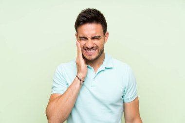 Diş ağrısı ile izole arka plan üzerinde yakışıklı genç adam