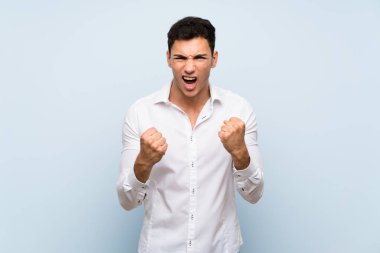 Mavi duvar üzerinde Yakışıklı adam kötü bir durum tarafından sinirli