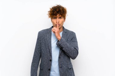 Sessiz jest ağzına parmak koyarak bir işareti gösteren izole beyaz duvar üzerinde moda Afrikalı Amerikan adam