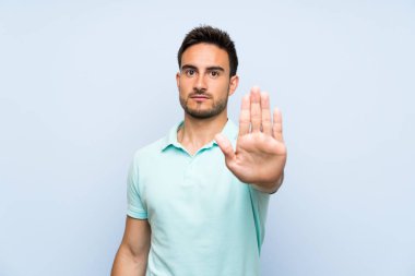 İzole arka planda yakışıklı genç adam stop jest yapma