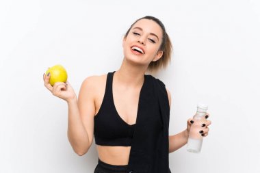 Bir elma ile beyaz duvar üzerinde genç spor kadın
