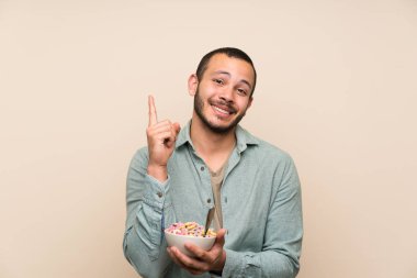 Büyük bir fikir indeks parmağı ile işaret tahıl kase ile Kolombiyalı adam