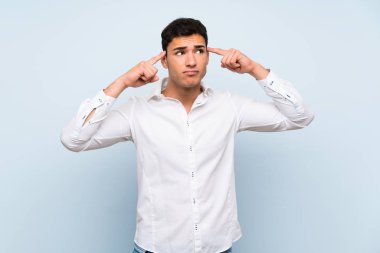 Mavi duvar üzerinde yakışıklı adam şüpheleri ve düşünme sahip