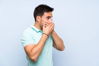 İzole arka plan üzerinde yakışıklı genç adam ağız kapsayan ve yan bakıyor