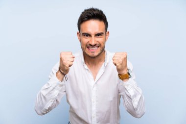 İzole mavi arka plan üzerinde yakışıklı genç adam kötü bir durum tarafından hayal kırıklığına