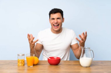 Kahvaltı mutsuz ve bir şey ile sinirli olan yakışıklı adam