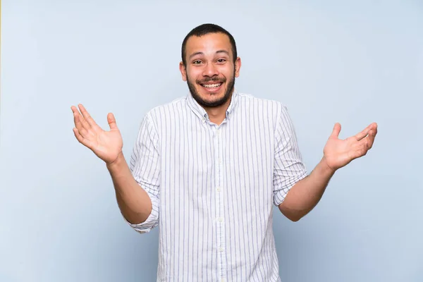 Hombre Colombiano Sobre Aislado Muro Azul Sonriendo Mucho —  Fotos de Stock