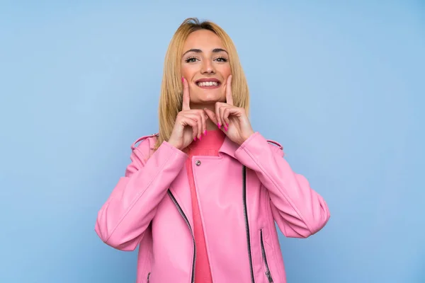 Молода Блондинка Рожевим Піджаком Над Ізольованим Синім Тлом Посміхається Щасливим — стокове фото