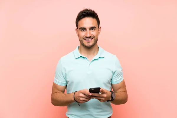 Joven Guapo Sobre Fondo Aislado Enviando Mensaje Con Móvil —  Fotos de Stock