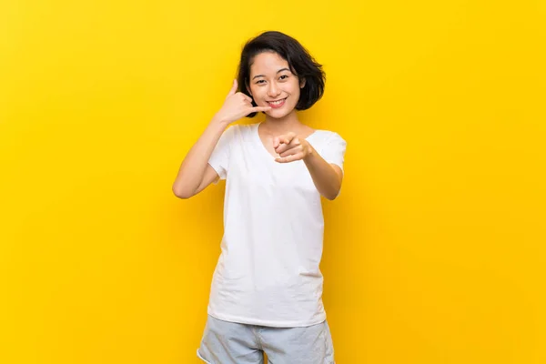 Asiatique Jeune Femme Sur Isolée Jaune Mur Faisant Geste Téléphone — Photo