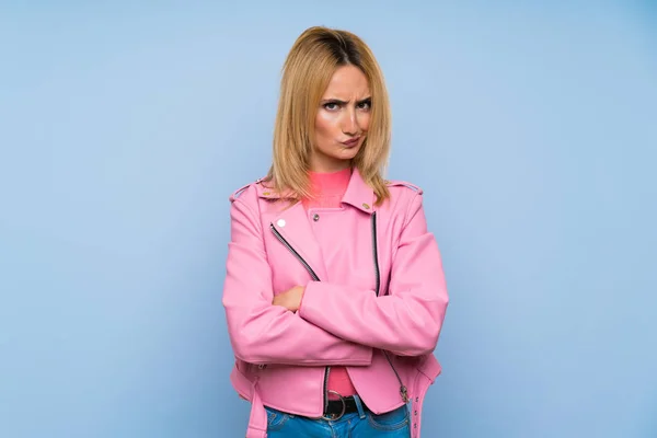 Молода Блондинка Рожевою Курткою Над Ізольованим Синім Фоном Відчуває Засмученість — стокове фото