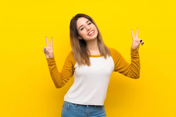 Mujer Joven Bonita Sobre Pared Amarilla Aislada Mostrando Signo Victoria —  Fotos de Stock