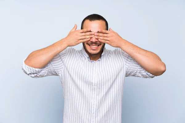 Kolumbijski Człowiek Białym Tle Niebieską Ścianę Pokrywającą Oczy Rękami — Zdjęcie stockowe