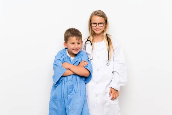 Little brothers playing to be doctors  over isolated white wall