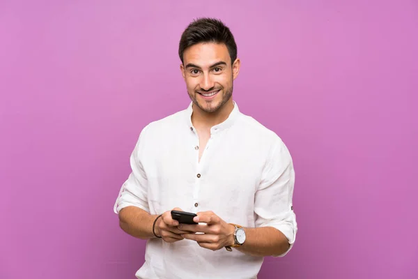 Joven Guapo Sobre Fondo Aislado Enviando Mensaje Con Móvil —  Fotos de Stock