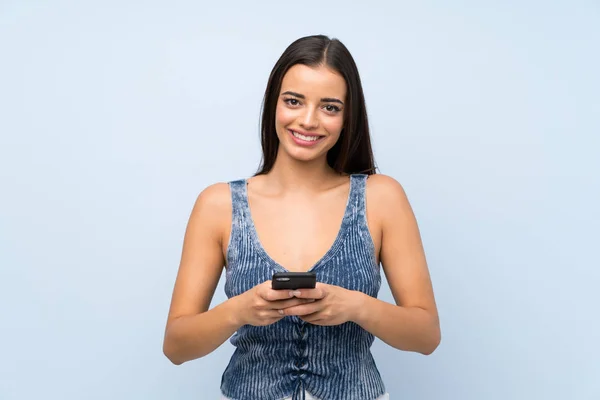 Giovane Donna Oltre Isolato Muro Blu Utilizzando Telefono Cellulare — Foto Stock