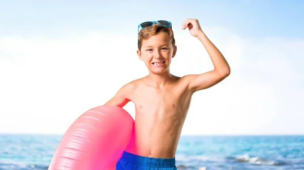 Child on summer vacation celebrating a victory at the beach