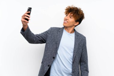 Moda African Amerikan adam üzerinde izole beyaz duvar bir selfie yapma