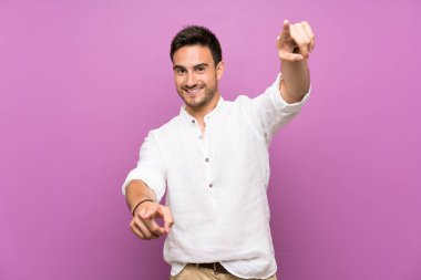 Gülümseyen sırasında izole arka plan puan parmak üzerinde yakışıklı genç adam