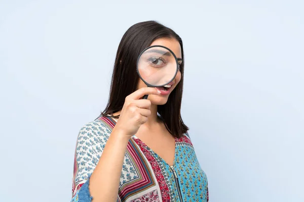 Jonge Vrouw Geïsoleerde Blauwe Muur Houden Van Een Vergrootglas — Stockfoto